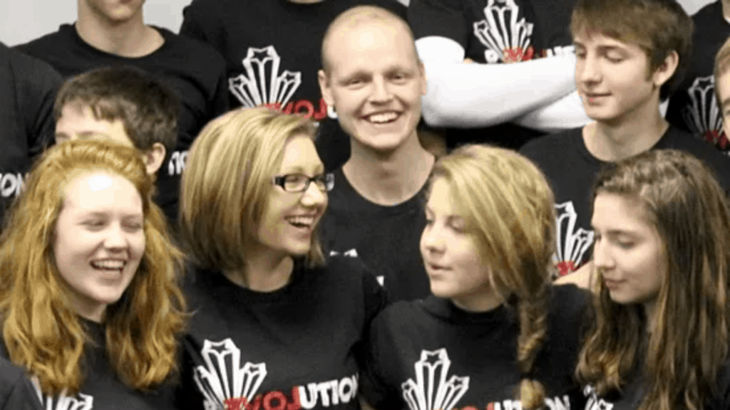 Zach, a teen in cancer treatment smiles with his friends at a Catholic youth retreat